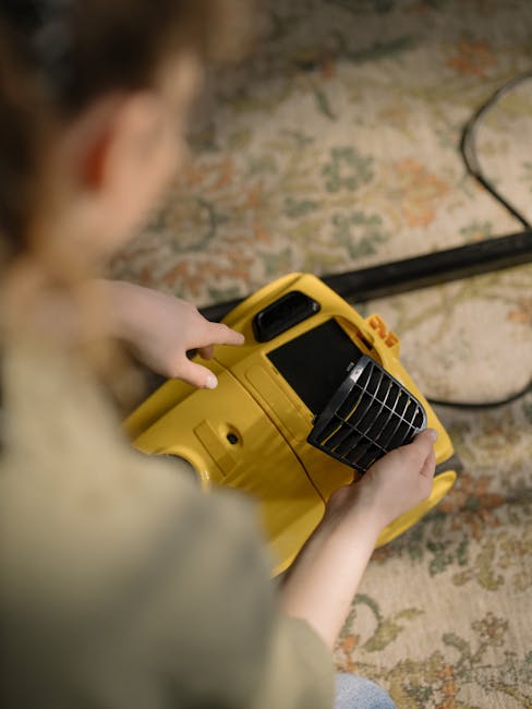 A professional cleaner from Lampton Carpet Cleaners dressed in white protective gear, including a full-body suit, face mask, and blue shoe covers, is performing deep surface cleaning on a beige carpet